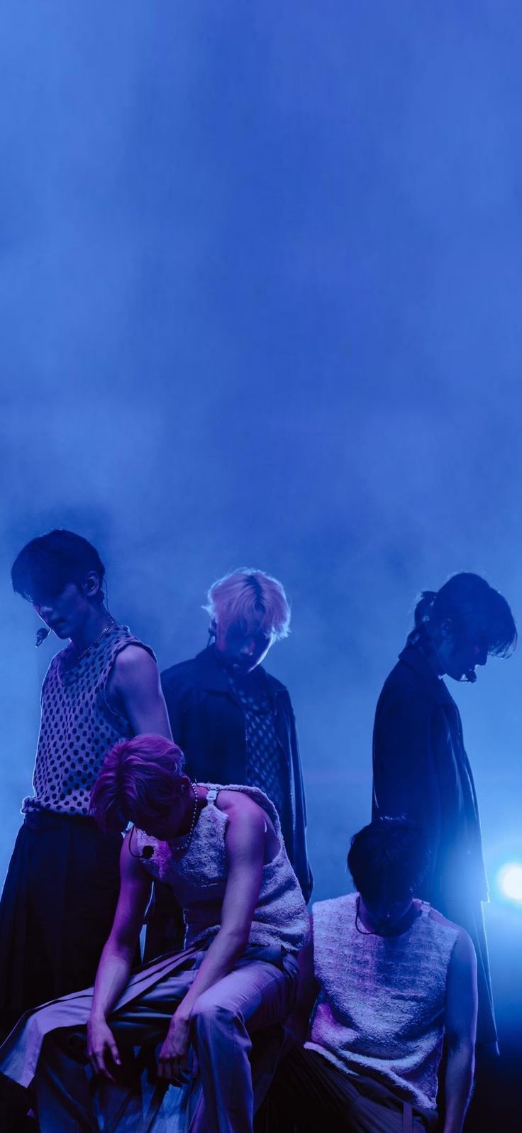 four people standing in front of a blue sky with the moon shining down on them