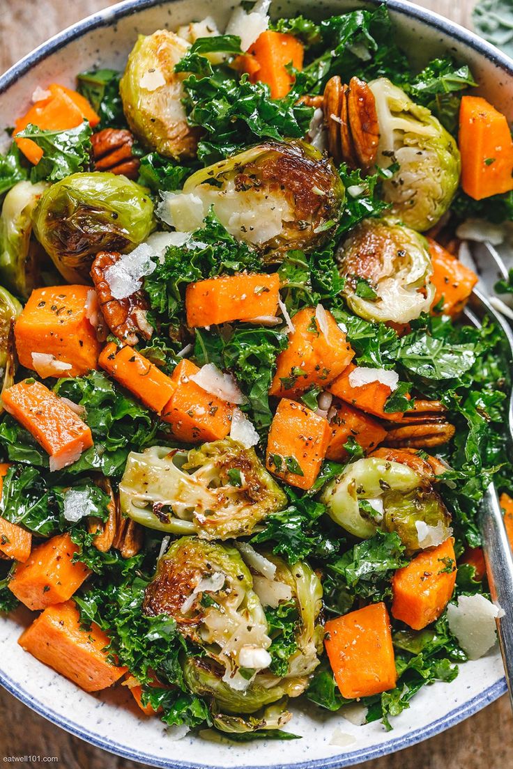 a bowl filled with brussel sprouts, carrots and other vegetables