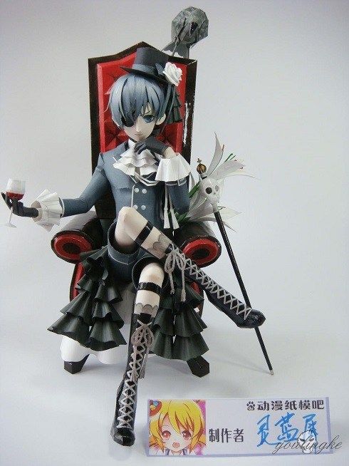 a figurine sitting on top of a red chair holding a glass in her hand