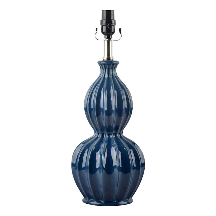 a large blue vase with a light on it's side and a black lamp in the middle