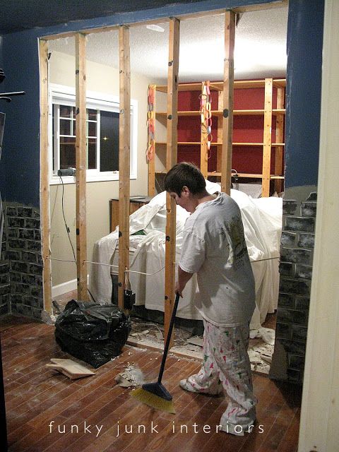 a man with a mop is standing in the middle of a room under construction