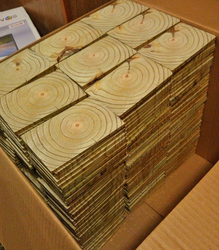 several pieces of wood stacked on top of each other in a cardboard box next to a book