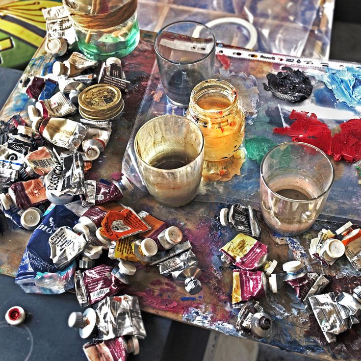 a table topped with lots of different types of paint and other things on top of it