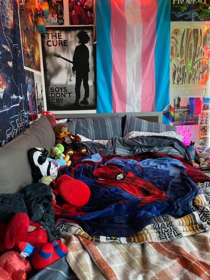 an unmade bed in a messy room with posters on the wall and stuffed animals