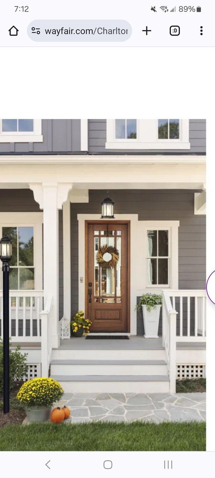 an image of a house with a clock on it's front door and porch