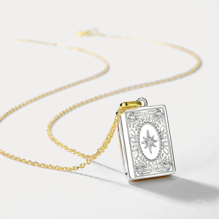 Surprise your loved ones with a treasured keepsake - the Gold and Silver Book Locket Necklace! This exquisite piece features a two-toned gold and silver locket adorned with intricate floral engravings, allowing you to keep cherished memories close. Nestled on radiant 10k gold on brass and accented with shimmering cubic zirconia, it offers a signature finish perfect for best friends, mothers, or partners. A sentimental gift celebrating the bonds you hold dear. 🎁 DETAILS Plating: 10K Gold  Materials: 10K Gold on Silver, Cubic Zirconia Measurements: Length: 15.75 "(40cm)   + Extender: 1.97"(5cm) Pendant Size: 0.47"*0.67"(1.2cm*1.7cm) Weight: 3.8 g Vintage Engraved Charm Necklaces For Keepsake, Gold Etched Locket Necklace For Keepsake, Vintage Engraved Charm Necklaces As Keepsakes, Antique Engraved Charm Necklaces For Gift, Gold Etched Locket Necklace, Vintage Charm Rectangular Pendant Jewelry As Gift, Vintage Charm Rectangular Pendant Jewelry For Gift, Keepsake Medallion Locket Necklace With Hallmark, Rectangular Pendant Locket Jewelry For Keepsake