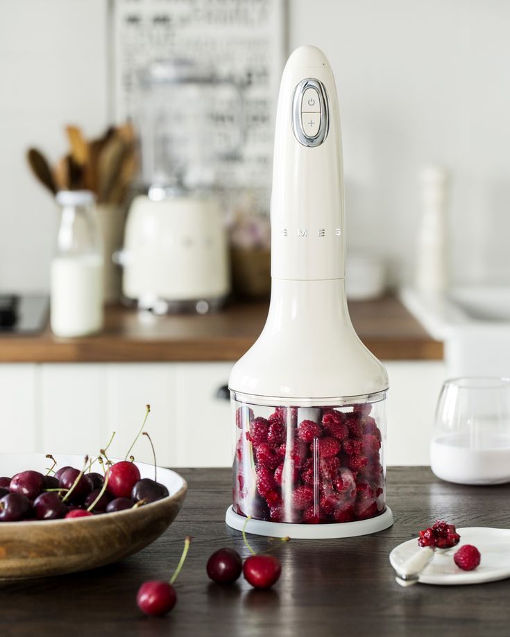 a food processor with cherries in it on a table