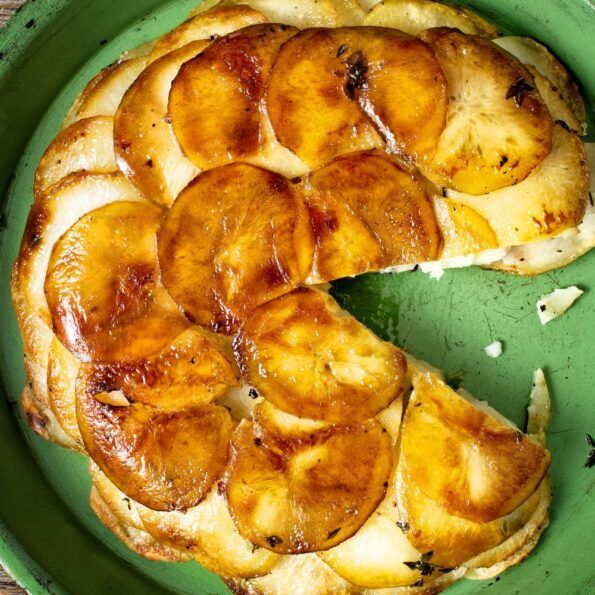 a green plate topped with sliced bananas on top of a wooden table