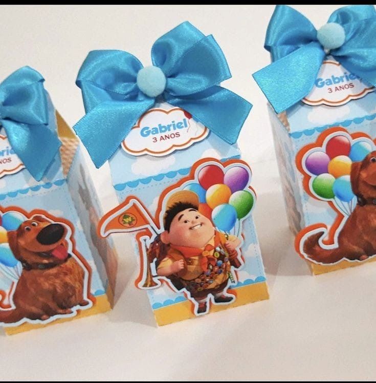 three boxes with blue bows and pictures of characters on them, one has a balloon in the shape of a dog