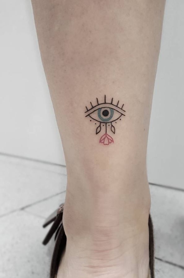 a woman's foot with an eye tattoo on the left side of her leg