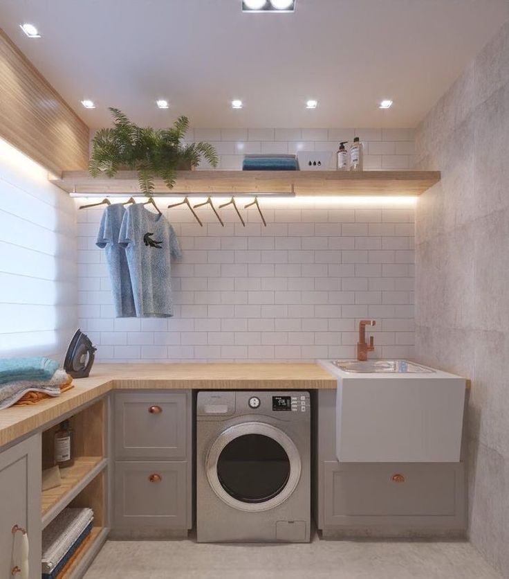 a washer and dryer in a small room with white tiles on the walls