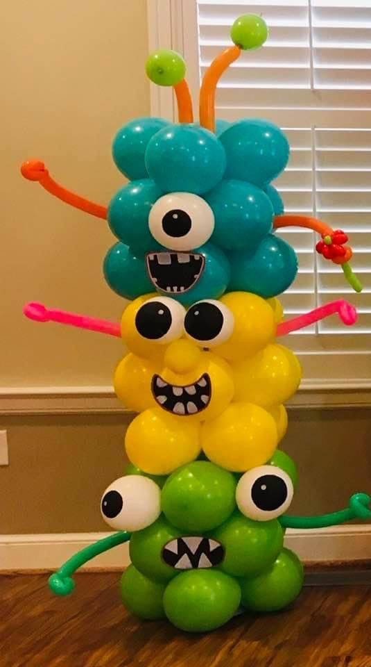 a bunch of balloons that are in the shape of a tower with googly eyes