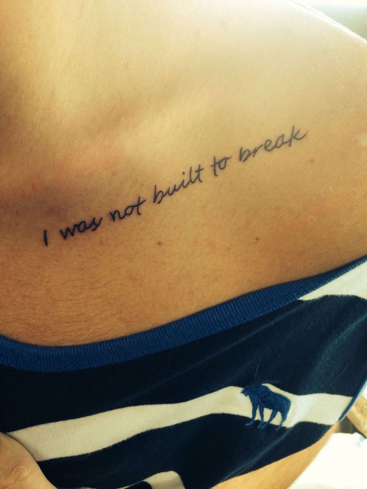 the back of a woman's stomach with a tattoo saying i was not built to break