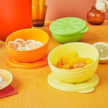 there are many different bowls on the table with lemons and oranges in them