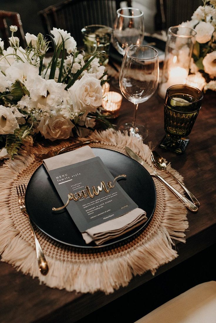 the table is set with an elegant menu and silverware, candles, and flowers