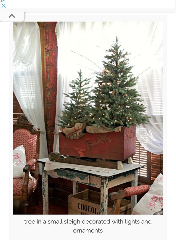 a small christmas tree in a wooden box on top of a table next to a window