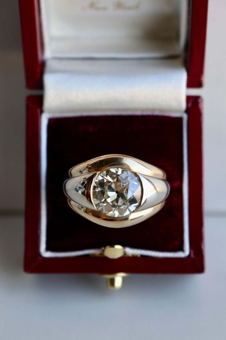 an engagement ring in a red velvet box with a white diamond on the top and bottom