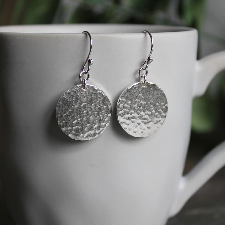 Do you need a gift for someone special? These simple sterling silver dangly hammered disc earrings are cute, simple & go with every outfit. Here are the details: This pair of earrings is made with solid sterling silver 3/4" diameter discs, have a hammered finish and are completed with handmade sterling silver ear wires. Hammered Round Disc Earrings For Gift, Hammered Round Disc Earrings As Gift, Nickel Free Silver Round Disc Earrings, Nickel-free Silver Round Disc Earrings, Sterling Silver Round Disc Jewelry With Matching Earrings, Sterling Silver Jewelry With Matching Earrings, Round Disc Shape, Sterling Silver Jewelry With Matching Earrings And Round Disc, Hammered Sterling Silver Round Disc Earrings, Sterling Silver Hammered Round Earrings