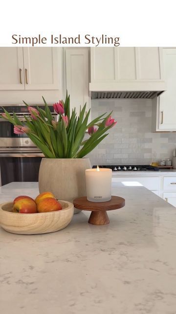 a kitchen counter with a bowl of fruit on it and a candle in the middle