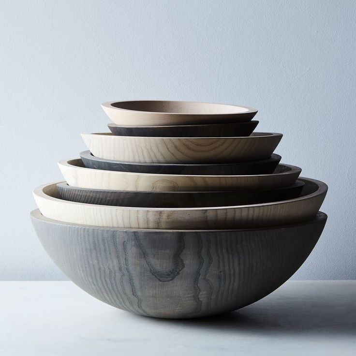 a stack of wooden bowls sitting on top of a table