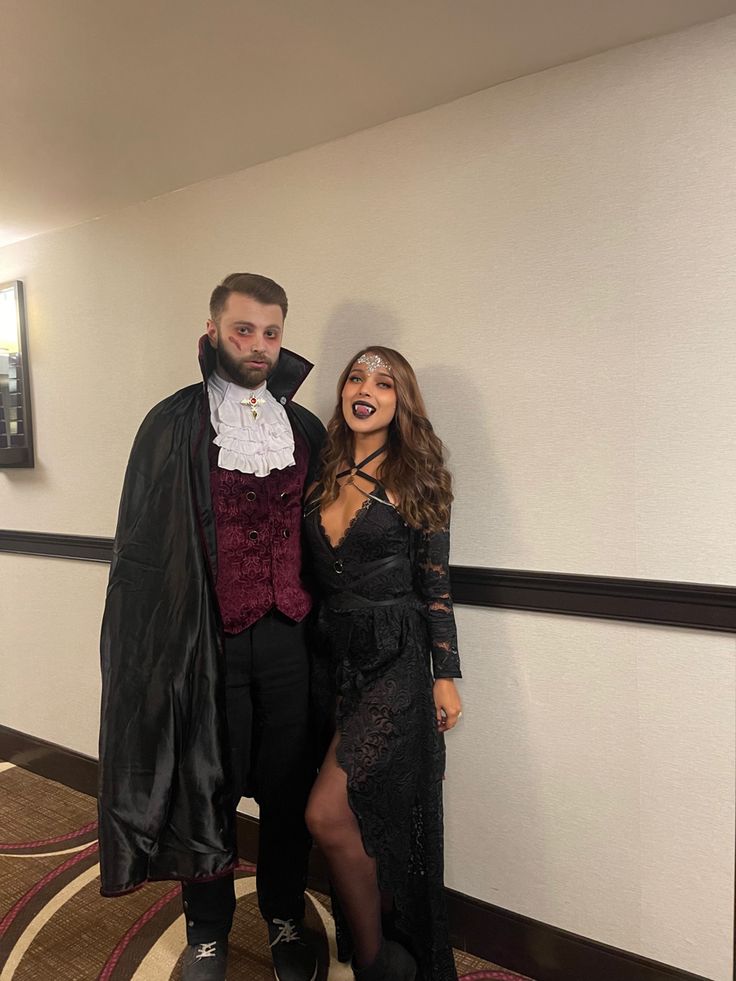 a man and woman dressed up in costume posing for a photo on the hallway way