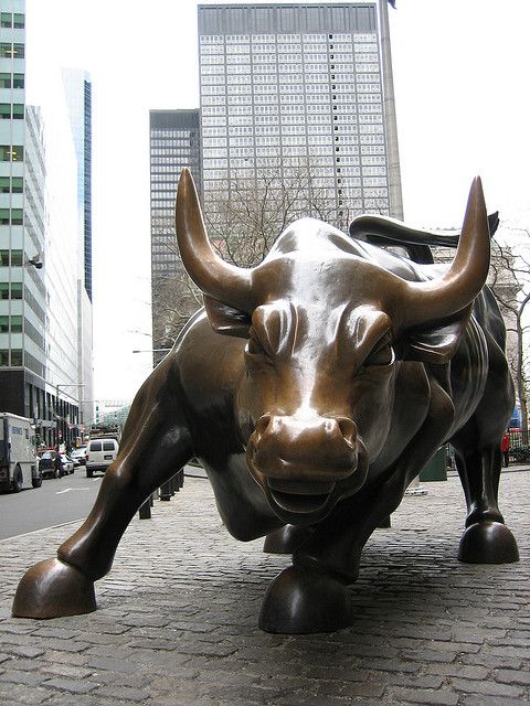 a statue of a bull on a brick sidewalk