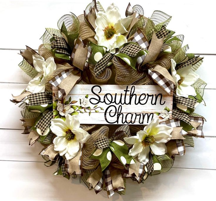 a wreath with the words southern charm on it and some flowers in front of it