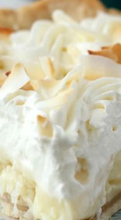 a piece of pie with white frosting on a blue and white plate next to a fork