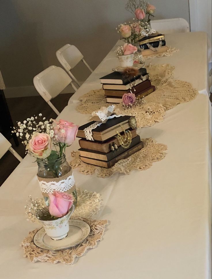 there are many books on the table with flowers in vases next to each other