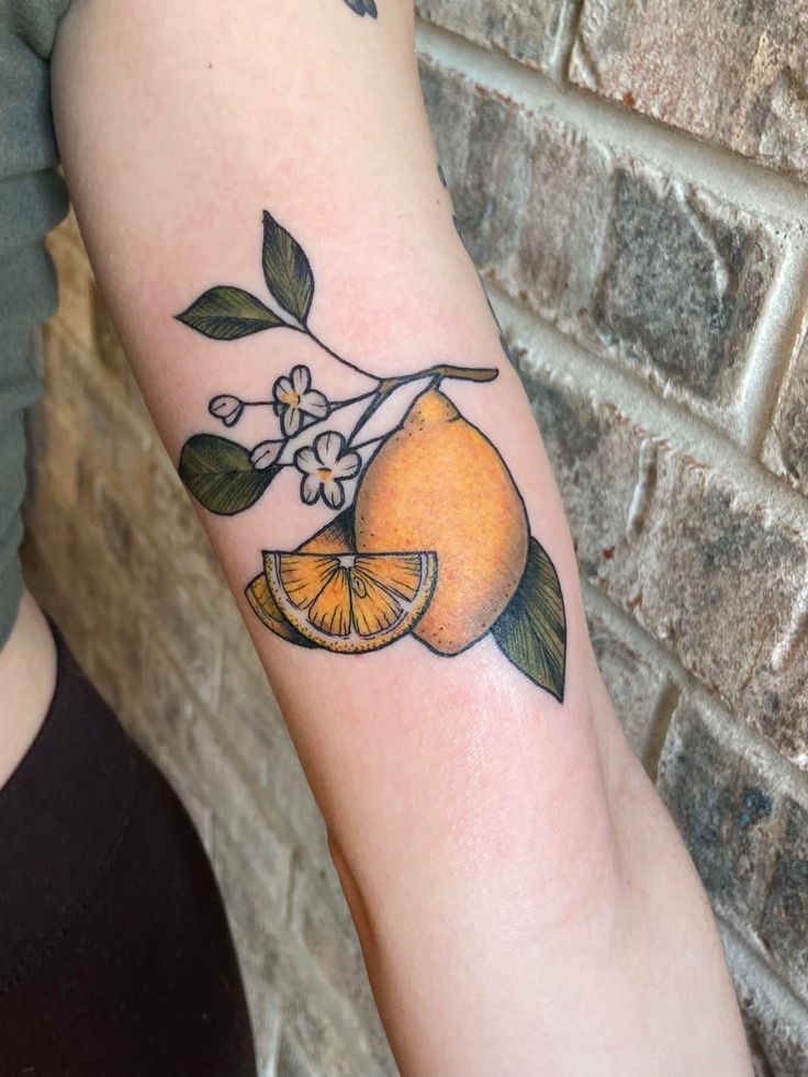 an orange with leaves and flowers on the arm