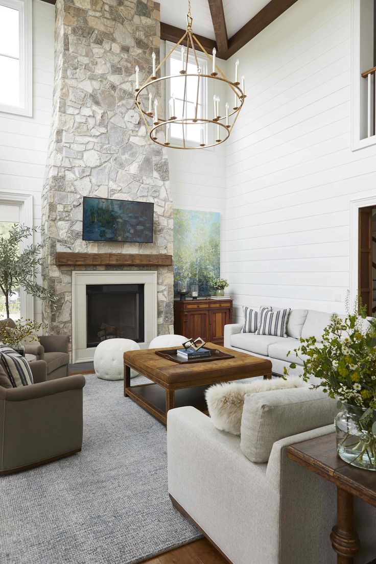 a living room filled with furniture and a fire place in front of a stone fireplace