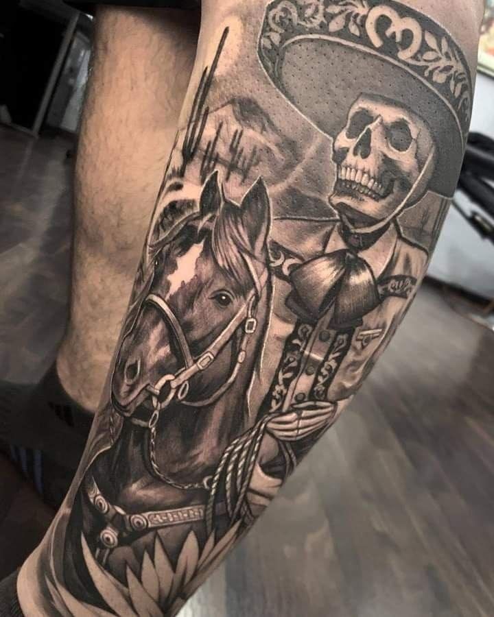 a man's leg with a skull and horse tattoo on it