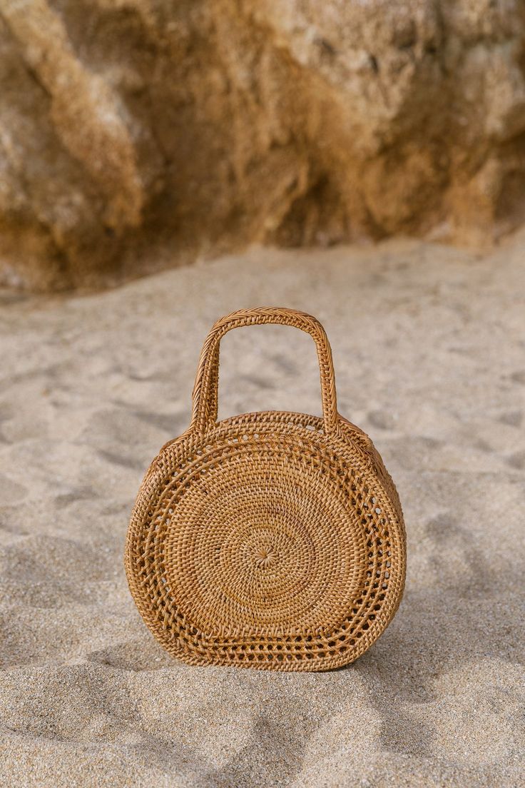 Collection of Tenganan Basket Bags against a sand background. - Saffron and Poe Oversized Lumbar Pillow, Basket Handbag, Purse Outfit, Euro Pillows, Handwoven Throw, Elevated Casual, Concentric Circles, Wicker Bags, Amazing Ideas