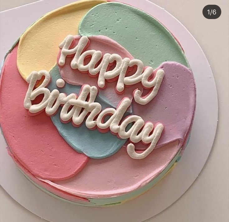 a birthday cake with the words happy birthday written on it in frosting and pastel colors