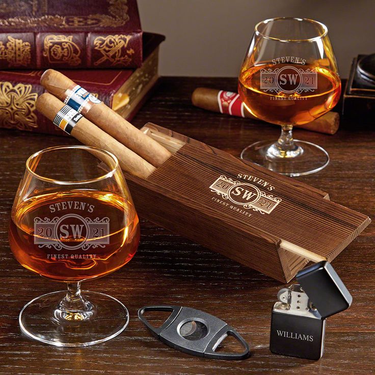 two cigars and some wine glasses on a table