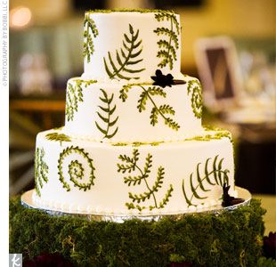 a three tiered cake decorated with green leaves