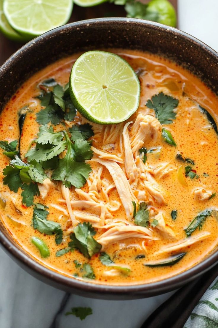 a bowl of chicken tortilla soup garnished with cilantro and lime