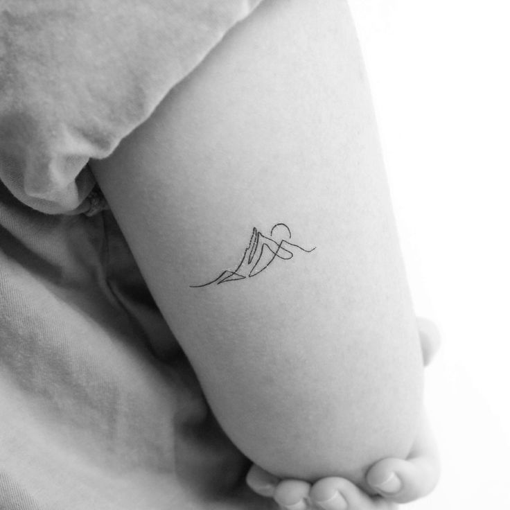 a woman's arm with a small tattoo on the left side of her body