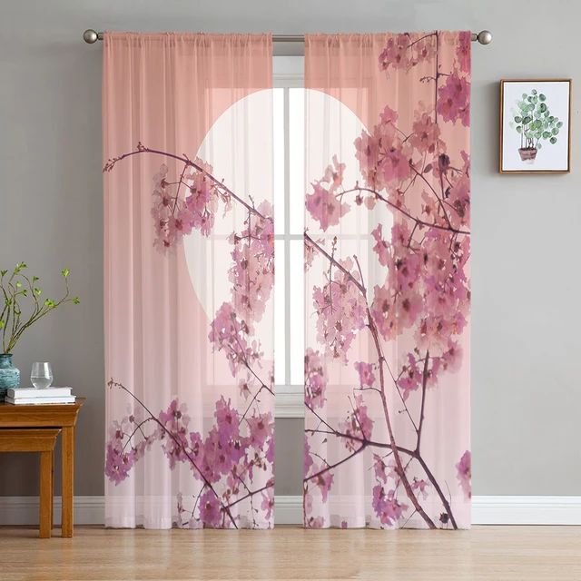 the curtains in this room are decorated with pink flowers and branches, along with a full moon behind them