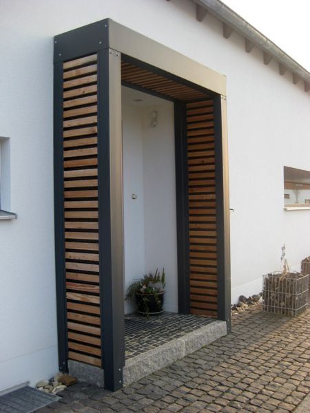 an open door on the side of a white building with wooden slatted doors