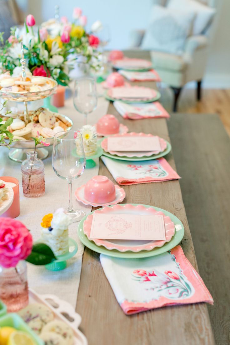 the table is set with pink and green plates