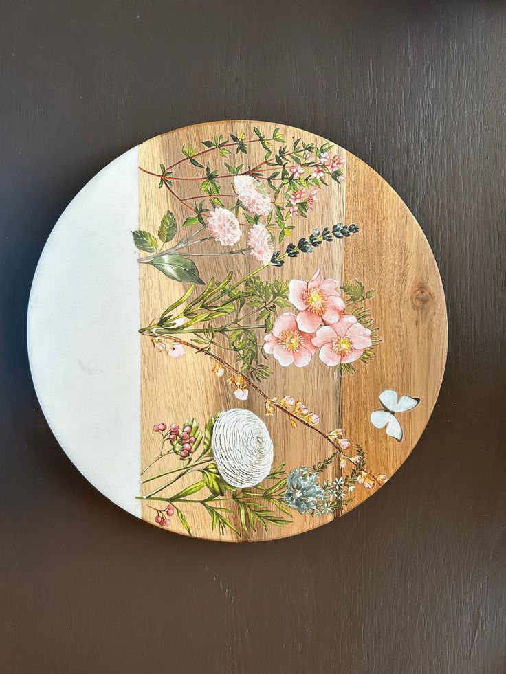 a wooden plate with flowers painted on it