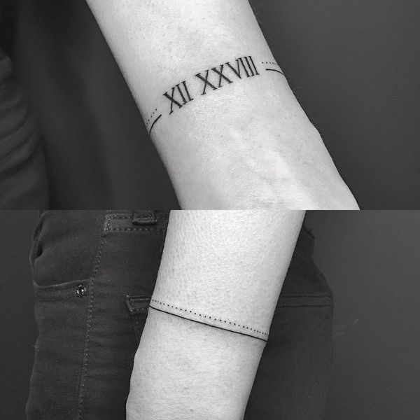 a wrist tattoo with roman numerals on the left arm and an arrow in the middle