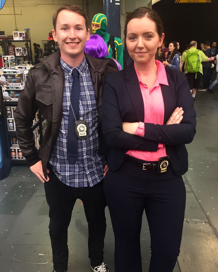 a man and woman standing next to each other in front of a store filled with people