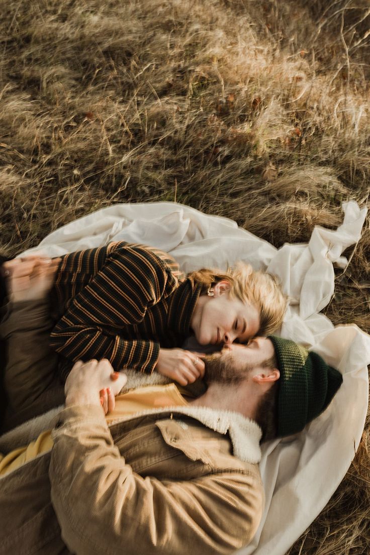 a man laying on top of a blanket next to a child