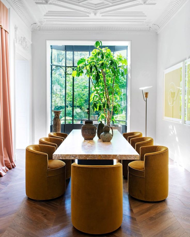 a dining room table with yellow chairs and a potted plant on the top of it