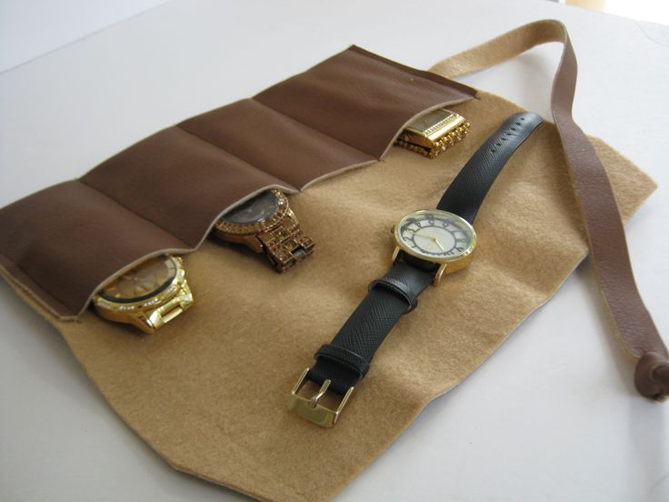 three watches are sitting on top of a piece of brown paper with a belt around it