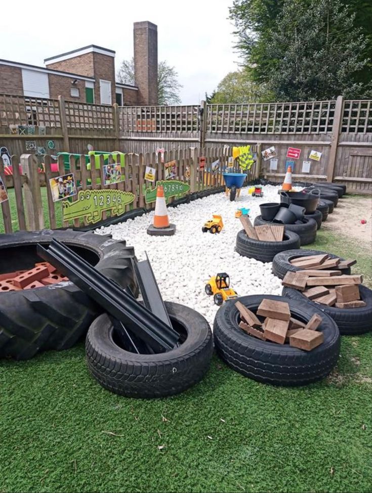 an outdoor play area with tires and construction equipment