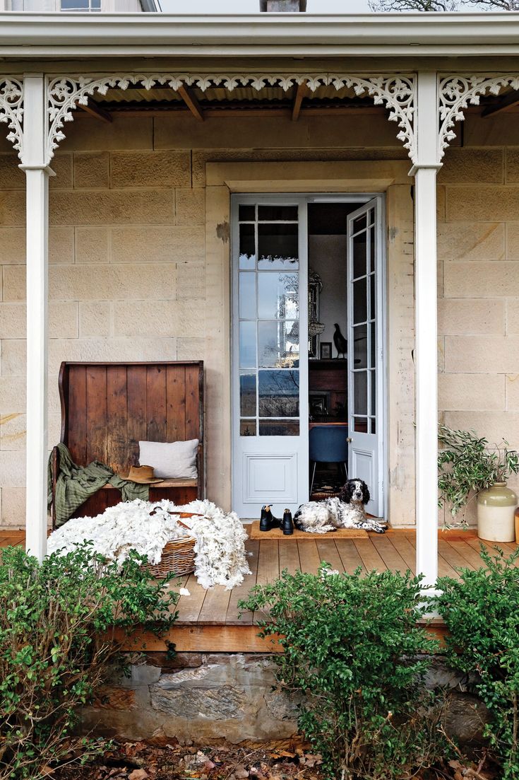 the front porch is decorated with flowers and plants