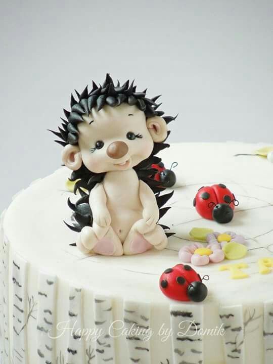 a cake with a hedgehog figurine sitting on top of it, surrounded by ladybugs